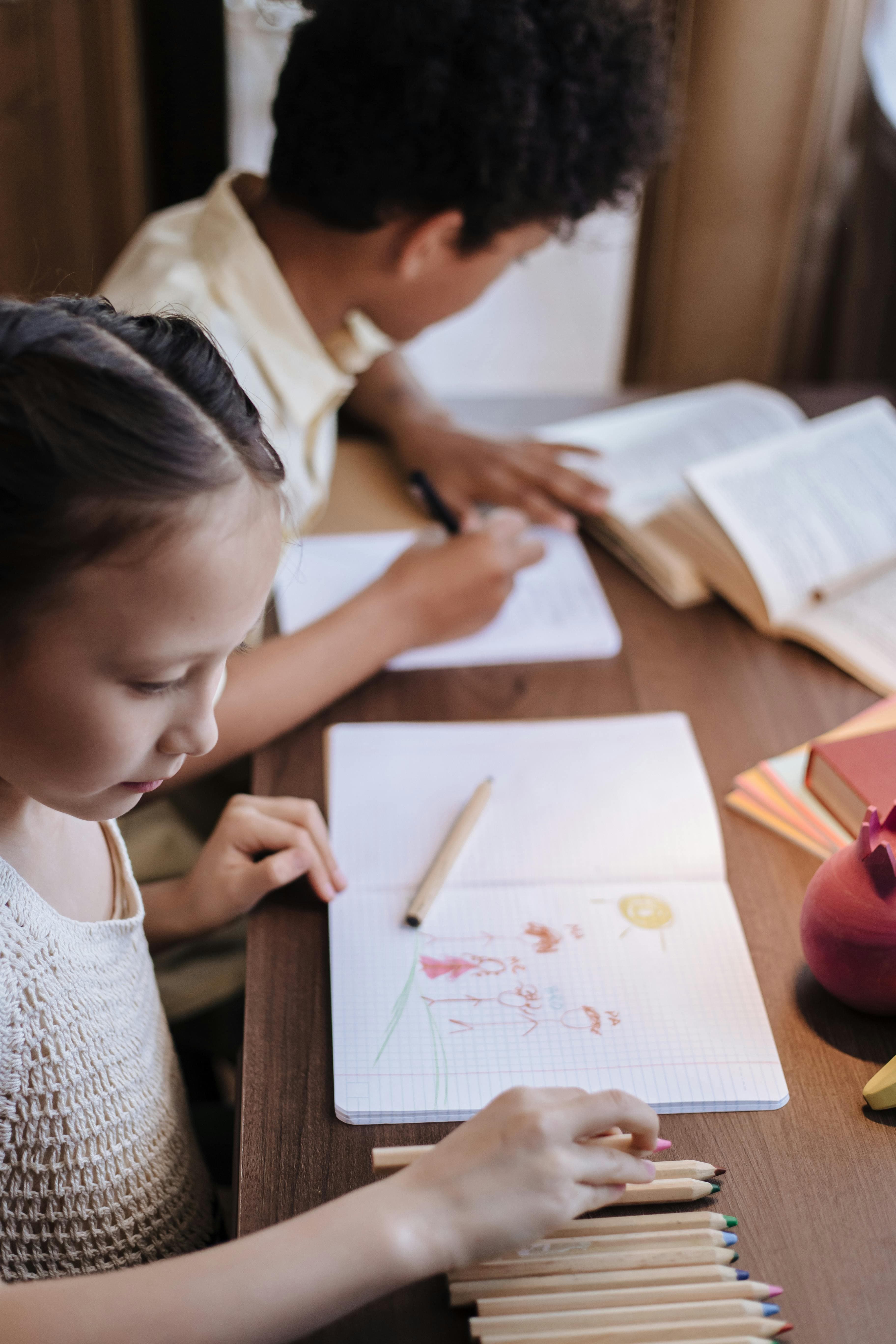 Niños estudiando con lápices de colores